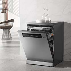 A sleek, modern stainless steel dishwasher with its door open, revealing clean dishes inside. It stands in a minimalist kitchen with soft lighting.