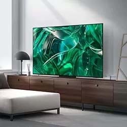 Modern living room with a large, sleek TV on a wooden console displaying abstract green swirls. A beige sofa and a stylish lamp complete the minimalist decor.