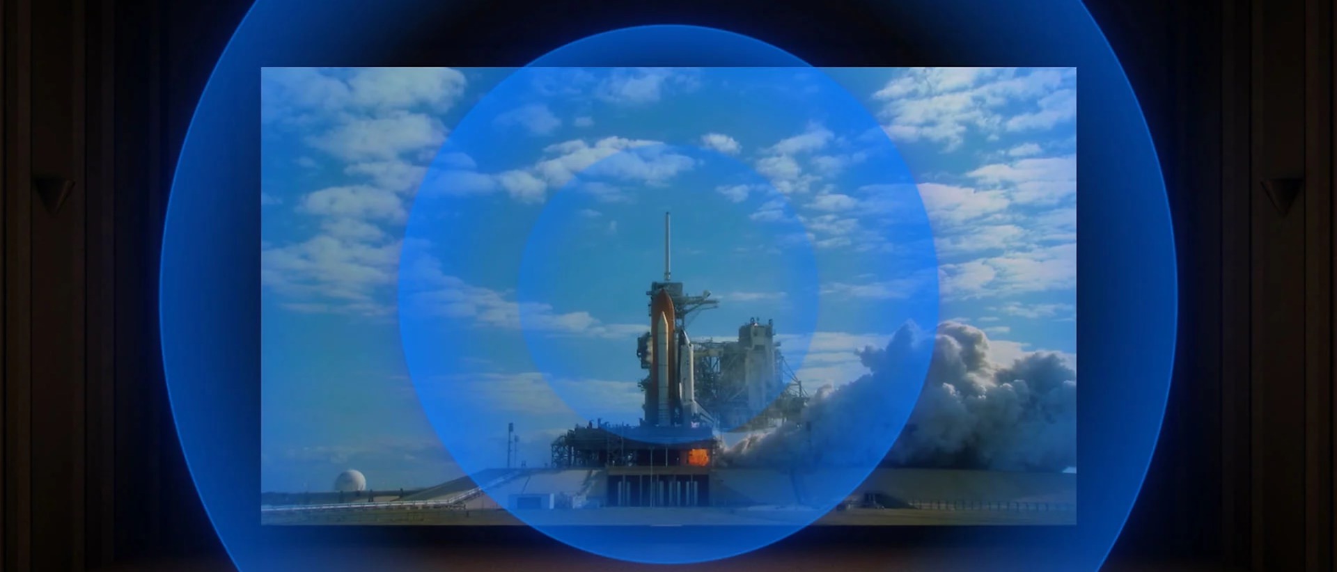 Close-up of a rocket taking off, followed by a cinema scene with sound waves radiating outward, illustrating BRAVIA 8’s immersive, side-mounted speakers.