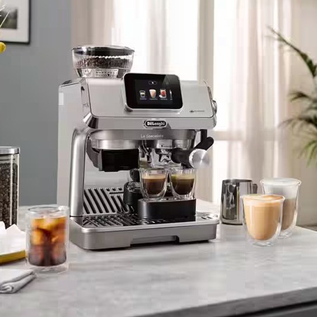 A sleek espresso machine on a kitchen counter brews two cups of espresso. Nearby are iced coffee and a latte, creating a cosy, inviting ambiance.