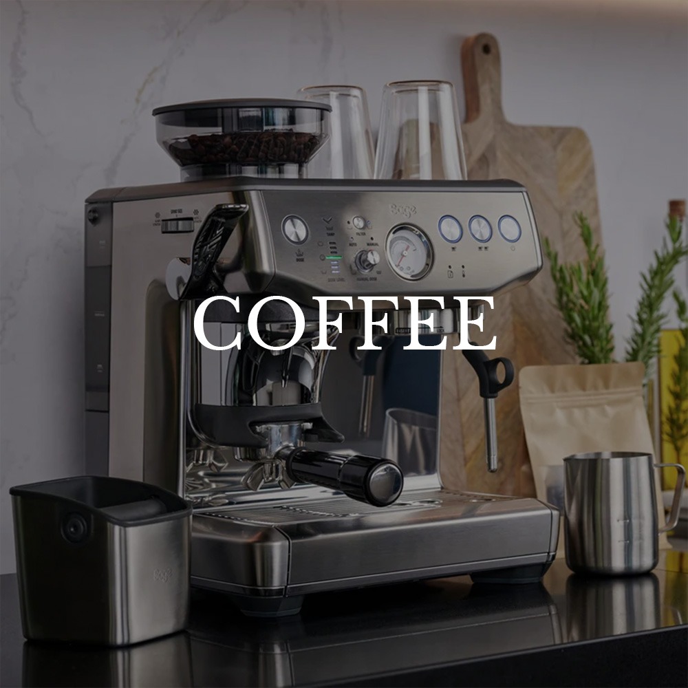 A sleek stainless steel espresso machine on a kitchen counter with cups and coffee beans in the background. The text "Coffee" overlays the image.