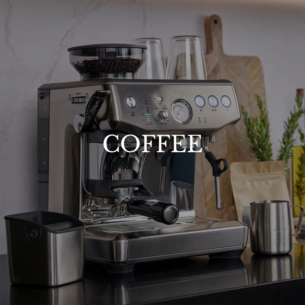 A sleek stainless steel espresso machine on a kitchen counter with cups and coffee beans in the background. The text "Coffee" overlays the image.
