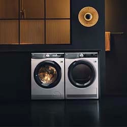 A sleek black toaster with two slices of bread on a kitchen counter, next to a sliced loaf and a soft-boiled egg in an egg cup.