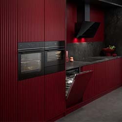 Floating against a textured grey background are various black KitchenAid appliances, including blenders, mixers, and an immersion blender.