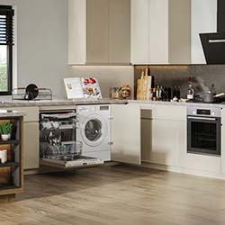 Modern kitchen with light wood flooring, white cabinets, and stainless appliances. Open dishwasher, cookbook, and decor items on the counter. Bright and tidy.