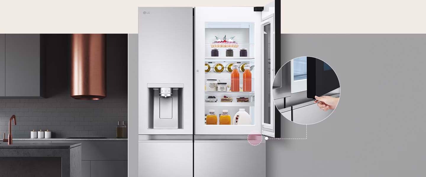 LG fridge with a visible interior stocked with drinks and desserts. A hand opens the sleek door. Modern kitchen.